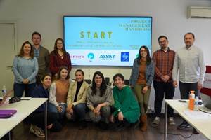 Un grupo de personas alrededor de una mesa posando para una foto
Descripción generada automáticamente