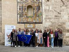Un grupo de personas posando delante de una pared de piedra
Descripción generada automáticamente con confianza media