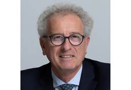 Un hombre con lentes y traje sonriendo
Descripción generada automáticamente